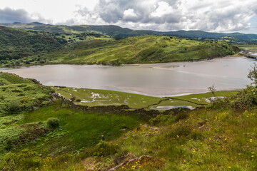 Banks of river in North Wales with tidal edge and pond wide angle.