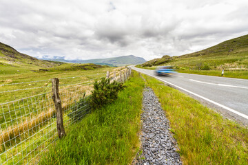 Blurred car Upland road through moorland in Eryri or Snowdonia national Park, Wales. - 679859989