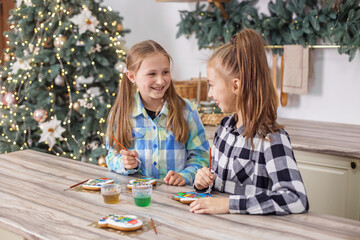Children draws food paints on Christmas homemade gingerbread cookies. Christmas concept