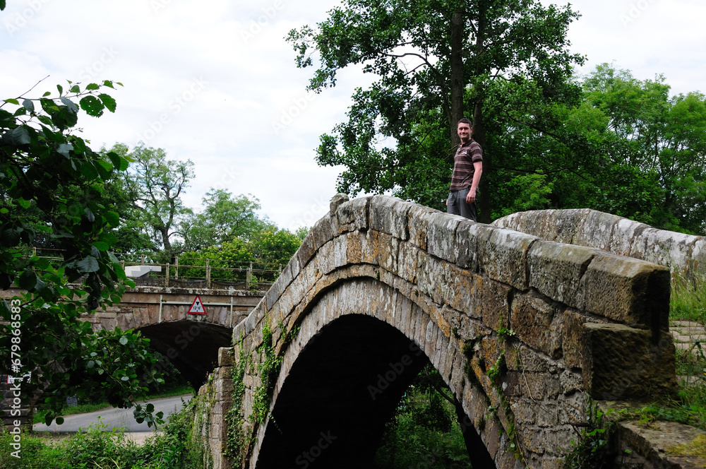 Wall mural man standing on a stone bridge in the uk