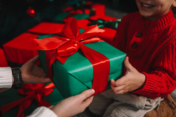 Gift box in the hands of mother and son, Christmas mood