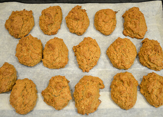 The finished oatmeal liver lies on a sheet of parchment on baking sheet. cooking baked goods in the home kitchen. delicious breakfast cookies for children and adults. dessert with milk, tea or coffee