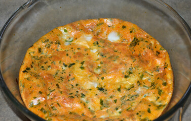 cooked baked omelet with tomatoes and herbs in a round shape. delicious and healthy breakfast food for children and adults. low-calorie, high-protein foods