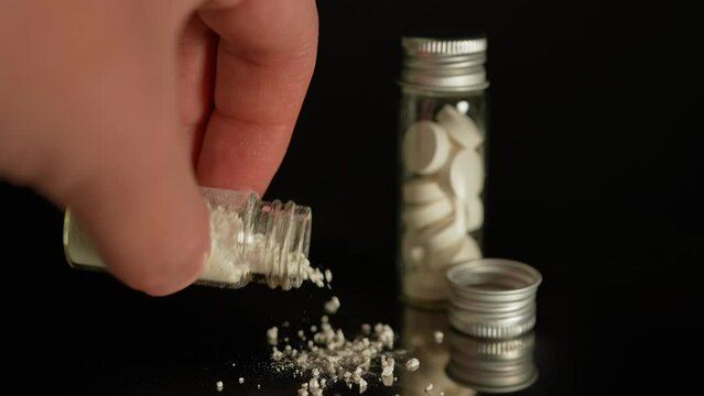 Illegal drug in powder in glass vial, substances abuse. Opioids and fentanyl crisis. Drug heroin, or crushed oxycodone packed in the bottle. Addicted people using for snorting.