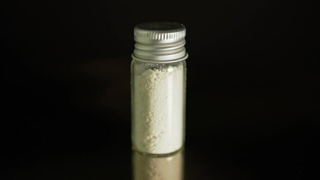 Illegal drug in powder in glass vial, substances abuse. Opioids and fentanyl crisis. Drug heroin, or crushed oxycodone packed in the bottle. Addicted people using for snorting.