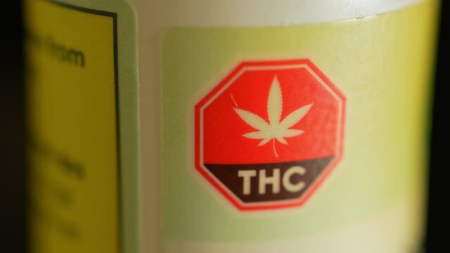 Macro close up of THC warning on the CBD bottle. CBD or cannabidiol made of Marijuana weed plant and have analgesic pain-relieving properties. CBD may provide relief for various types of pain.