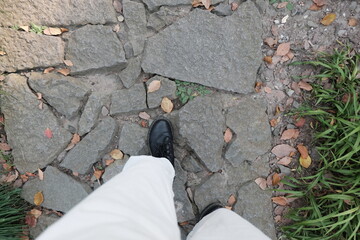 person leg and boots walking on the ground