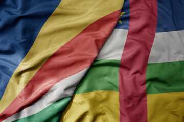 big waving national colorful flag of seychelles and national flag of central african republic .