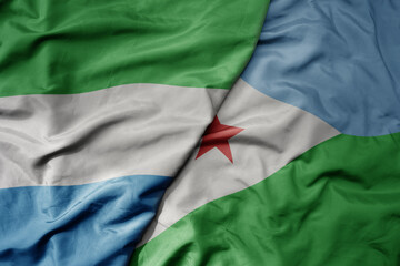 big waving national colorful flag of sierra leone and national flag of djibouti .
