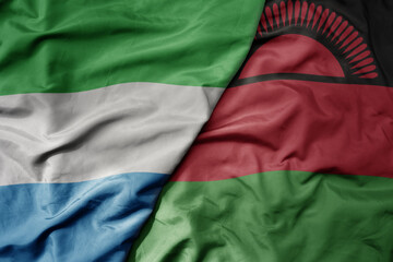 Obraz premium big waving national colorful flag of sierra leone and national flag of malawi .