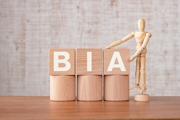 There is wood cube with the word BIA. It is an abbreviation for Business Impact Analysis as...