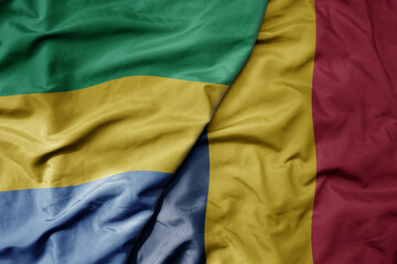big waving national colorful flag of chad and national flag of gabon .