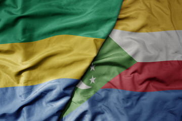 Obraz premium big waving national colorful flag of comoros and national flag of gabon .