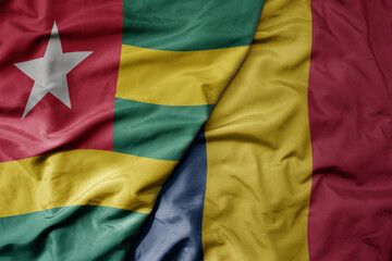 big waving national colorful flag of chad and national flag of togo .