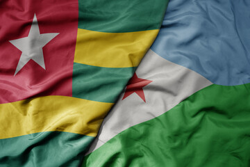 Obraz premium big waving national colorful flag of djibouti and national flag of togo .