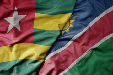 big waving national colorful flag of namibia and national flag of togo .