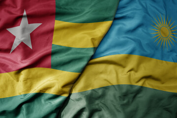 big waving national colorful flag of rwanda and national flag of togo .