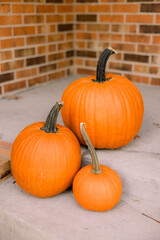 Trio of pumpkins on a porch for October and Halloween