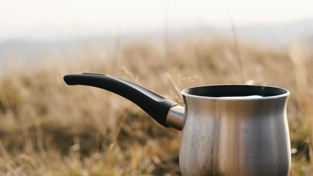 Making v60 coffee on portable camping gas burner with Carpathian mountains nature background.