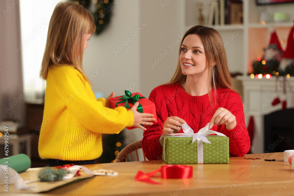 Poster Christmas presents wrapping. Mother and her little daughter with gift boxes at table in room