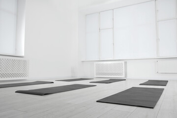 Spacious yoga studio with exercise mats and big windows, low angle view