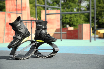 Stylish kangoo jumping boots in workout park. Space for text