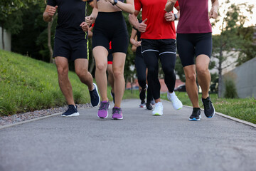 Group of people running outdoors, closeup view