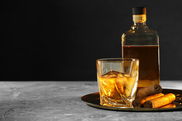 Tray with whiskey and cigars on grey table. Space for text