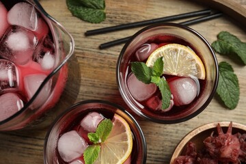 Delicious iced hibiscus tea with mint on wooden table, flat lay