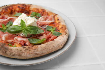 Delicious pizza with burrata cheese, basil and ham on white table, closeup. Space for text