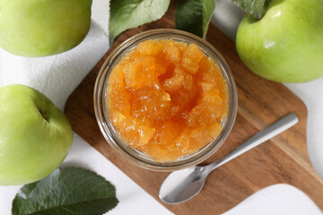 Glass jar of delicious apple jam and fresh fruits on white table, flat lay