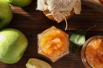 Delicious apple jam and fresh fruits on wooden table, flat lay