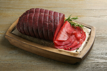 Tasty bresaola, peppercorns and rosemary on wooden table