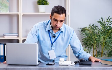 Young male travel agent working in the office
