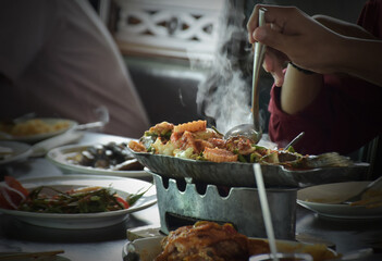 Thai style food spicy. Fried snakehead Fish in Spicy Sour Soup. People holding ladle in the hand for preparing dinner.