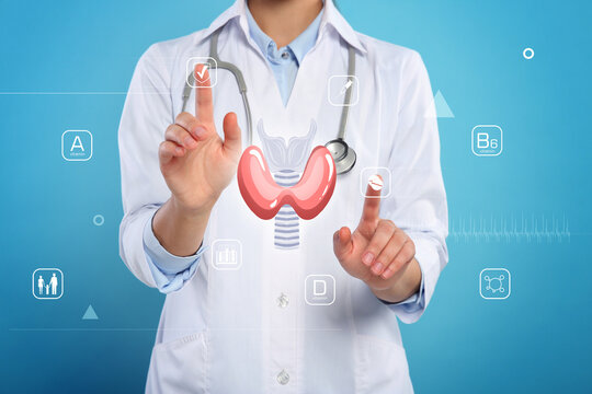Diagnosis and treatment of thyroid diseases. Endocrinologist using virtual screen with thyroid gland and icons on light blue background, closeup