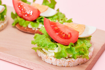 Rice Cake Sandwiches with Tomato, Lettuce and Egg on Wooden Cutting Board. Easy Breakfast. Diet Food. Quick and Healthy Sandwiches. Crispbread with Tasty Filling. Healthy Dietary Snack