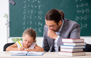 Teacher with young girl in the classroom