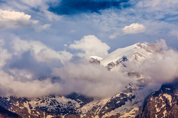 Fototapeta na wymiar Snowcapped summit top of mountain in Himalayas in clouds. Himachal Pradesh, India