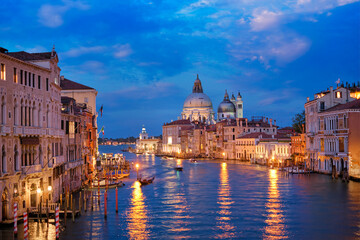 Fototapeta na wymiar View of Venice Grand Canal with boats and Santa Maria della Salute church in the evening from Ponte dell'Accademia bridge. Venice, Italy