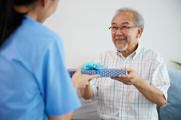 senior man giving present or gift from caregiver for happy birthday