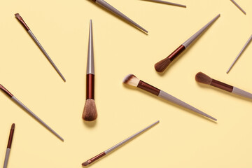 Makeup brushes on yellow background