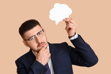 Young businessman with speech bubble on beige background. Business idea concept