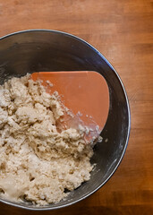 The beginning of the bread making process.  Dough is being mixed in a steel bowl