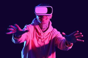 Young man using VR glasses on dark background