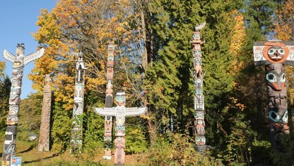 Pan left to right along the famous First Nations Totem Poles in Stanley Park during a fall season in Vancouver, British Columbia, Canada