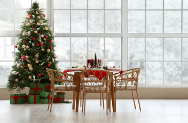 Interior of room with festive dining table and Christmas tree