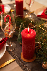 Burning candle on festive table at Christmas night, closeup