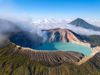 Aerial view of rock cliff at Kawah Ijen volcano with turquoise sulfur water lake at sunrise.Amazing nature landscape view at East Java, Indonesia.Natural landscape colorful sky background © Panya