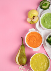 Bowls with baby food on pink background. Healthy eating concept.